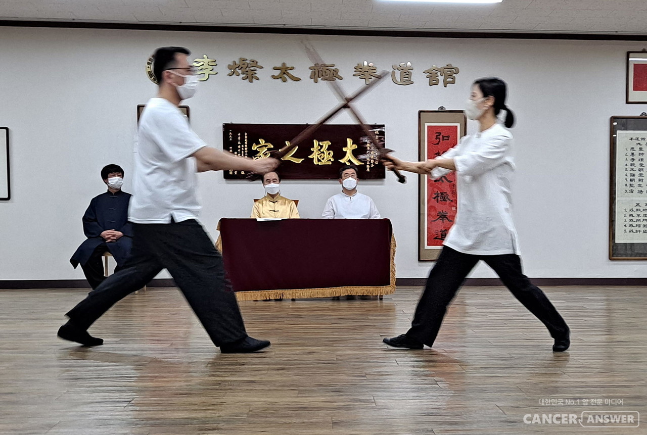 승단심사를 받고 있는 두 수련생이 태극검 대련을 하고 있다. / 이찬태극권도관