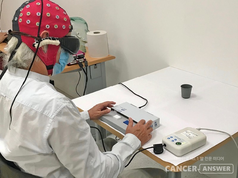 빛을 감지하는 장치를 사용해 흰 테이블 위의 검은 컵이 보이는지 안보이는지 실험을 진행하고 있다. / Nature Medicine