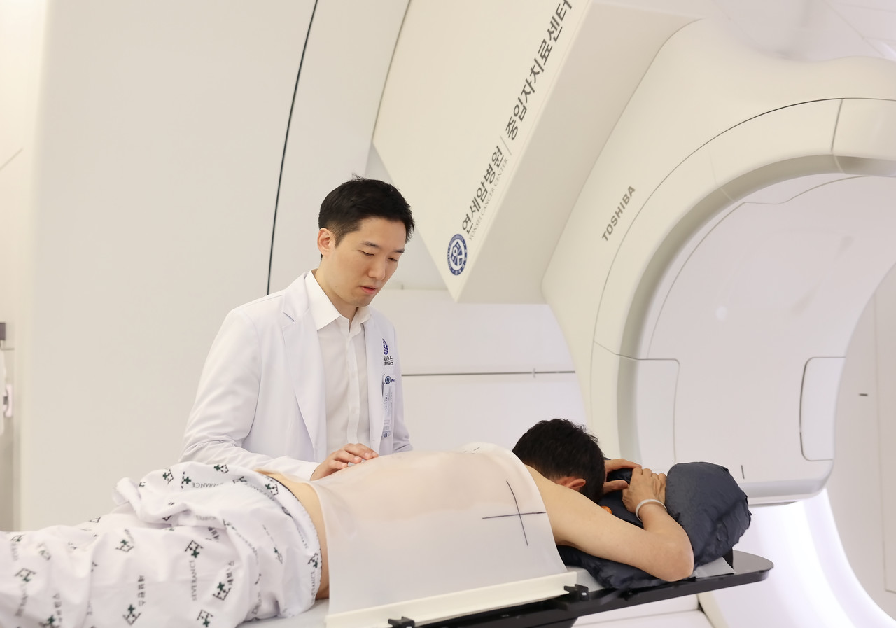 연세암병원 김경환 방사선종양학과 교수가 폐암 중입자치료 치료 시작 전 환자를 살피고 있다./연세암병원 제공