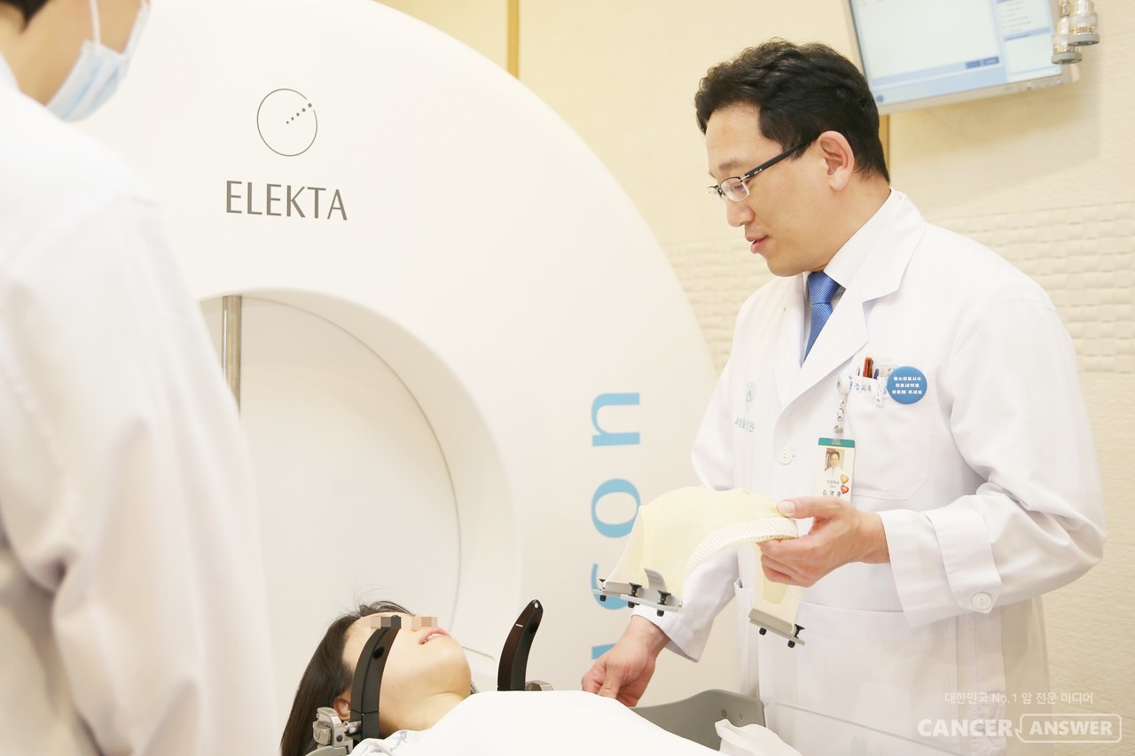 서울아산병원 신경외과 김영훈 교수가 '하부 뇌 신경초종' 환자에게 감마나이프 수술 전 치료 과정을 설명하고 있다./서울아산병원제공