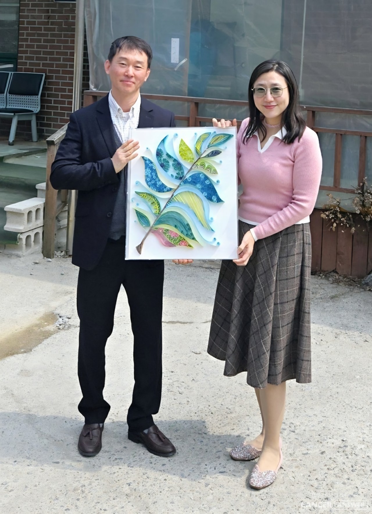 홍유진 캔드림협동조합 이사장(오른쪽)이 박준호 조합원에게 김소라 종이공예 작가의 작품 '희망의 깃털'을 전달했다. ‘앎경험자 나의 이야기’ 공모전은 캔드림과 후불제 상조회사 예담라이프가 함께 진행한다./캔드림협동조합 제공